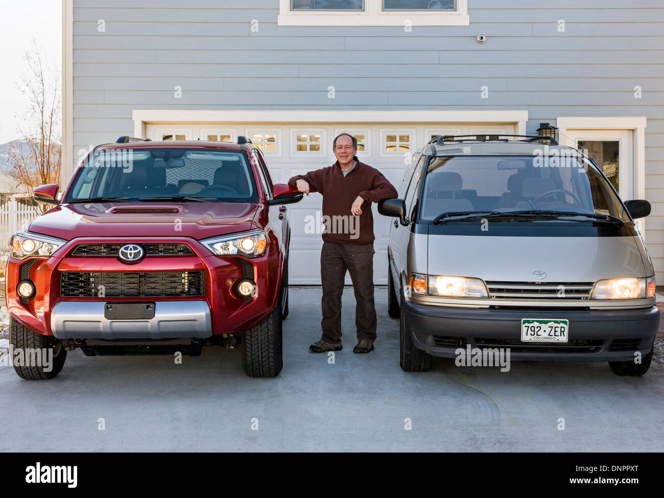Middle-aged man posing with 2014 Toyota 4Runner Trail Premium & 1996 Toyota Previa LE/SC AWD Banque D'Images