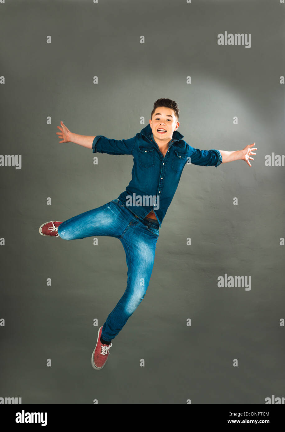 Portrait of Teenage Boy Jumping in Midair, Studio Shot Banque D'Images