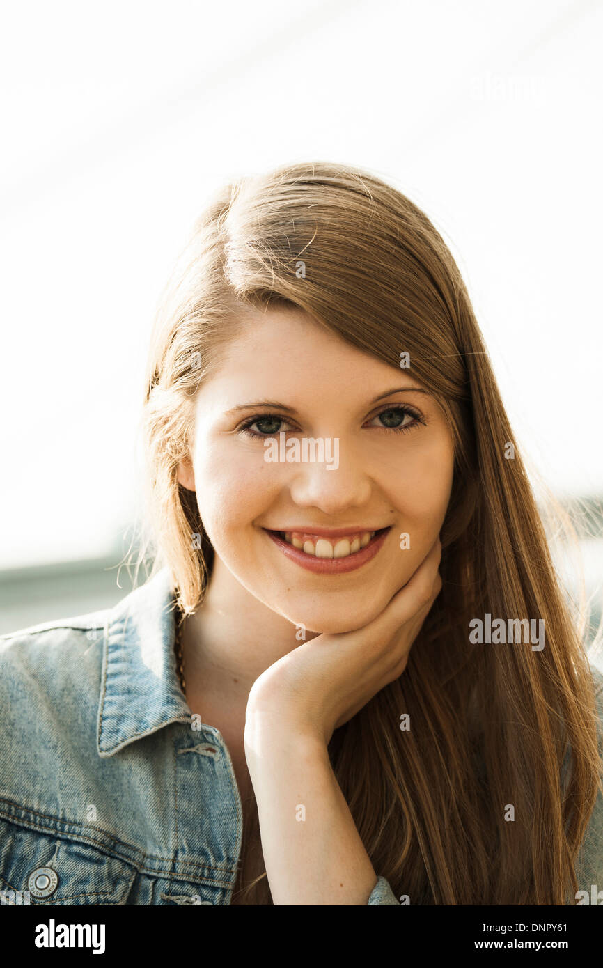 Portrait of young woman outdoors, smiling at camera Banque D'Images