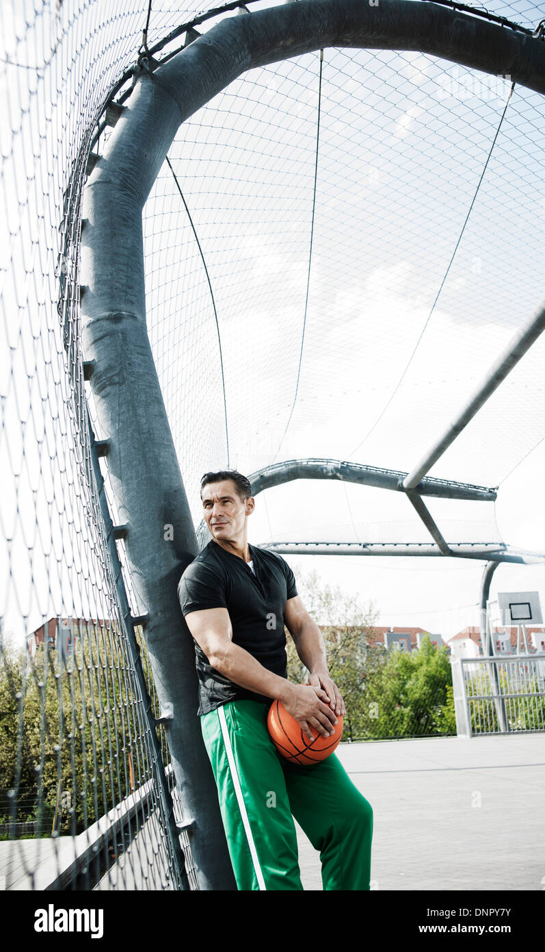 Man Standing on outdoor outdoor basketball, Allemagne Banque D'Images