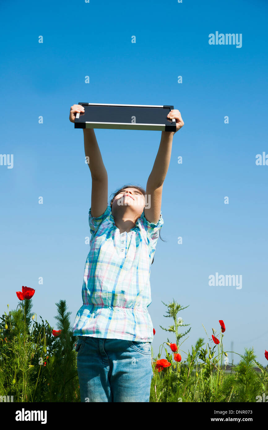 Girl Holding Panneau solaire jusqu'à l'air, Mannheim, Baden-Wurttemberg, Germany Banque D'Images
