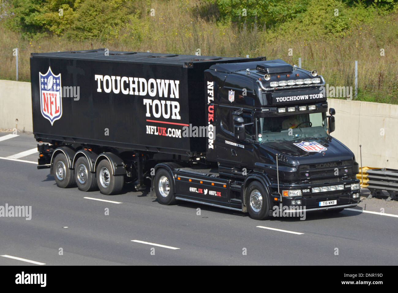 Publicité et publicité pour camion et remorque Scania 164 580 en bonnette noire et promotion de la NFL UK Touchdown Tour conduite le long de l'autoroute M25 Essex Angleterre Royaume-Uni Banque D'Images