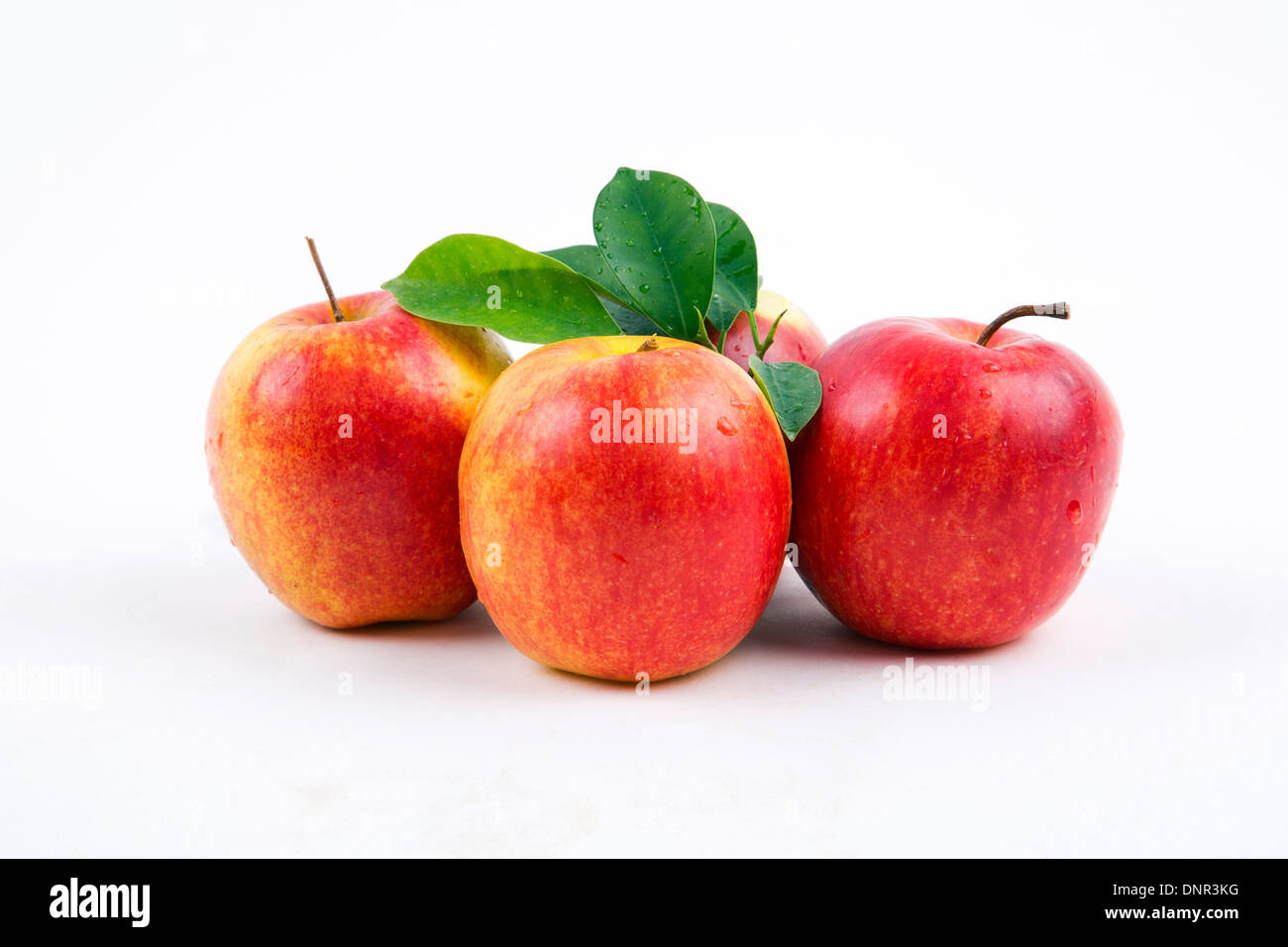 Les pommes fraîches avec des feuilles sur un fond blanc. Banque D'Images