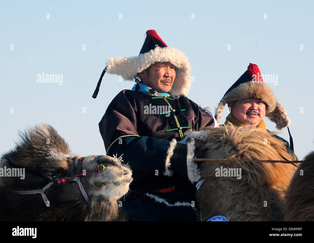 Bannière Ujimqin ouest, la Région autonome de Mongolie intérieure. 4 janvier, 2014. Deux bergers en tenue traditionnelle de l'ethnie mongole attendre à participer aux courses de chameaux à un carnaval de glace et de neige dans l'ouest de bannière Ujimqin, Chine du nord, région autonome de Mongolie intérieure, le 5 janvier 2014. Le carnaval d'hiver dure du 4 janvier au 5 janvier ici. Credit : Wang Song/Xinhua/Alamy Live News Banque D'Images