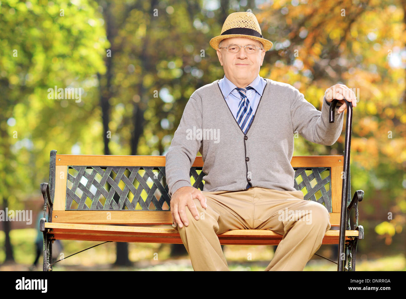 La haute atmosphère gentleman assis sur un banc dans un parc Banque D'Images
