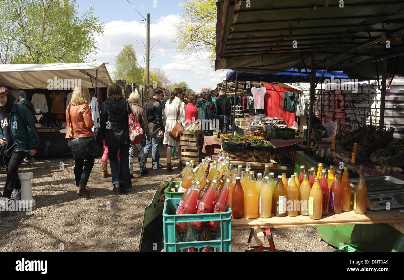 Le Sunny View people walking cours des bouteilles de jus de pomme sur une table à un étal vendant des produits de la ferme, marché aux puces de Mauerpark, Berlin Banque D'Images