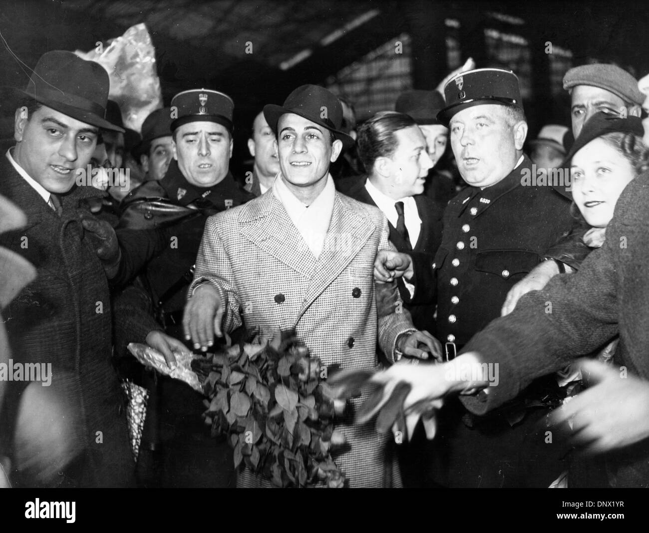 25 avril 1937 - Paris, France - l'acteur français Tino Rossi d'être escorté par des policiers dans une foule de fans. (Crédit Image : © Keystone Photos USA/ZUMAPRESS.com) Banque D'Images