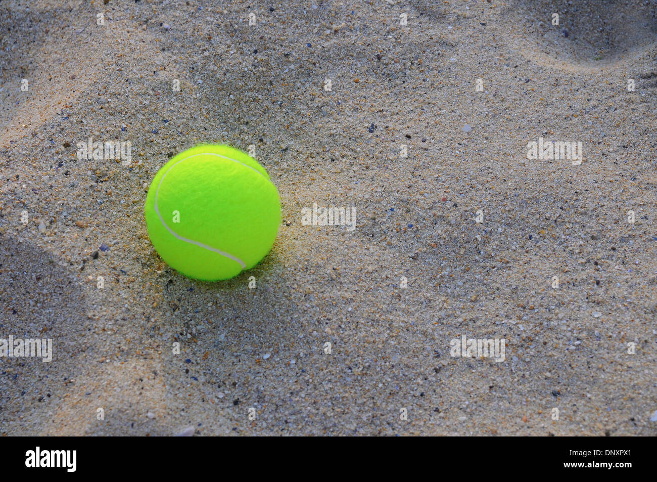 Balle de tennis sur le sable. Banque D'Images