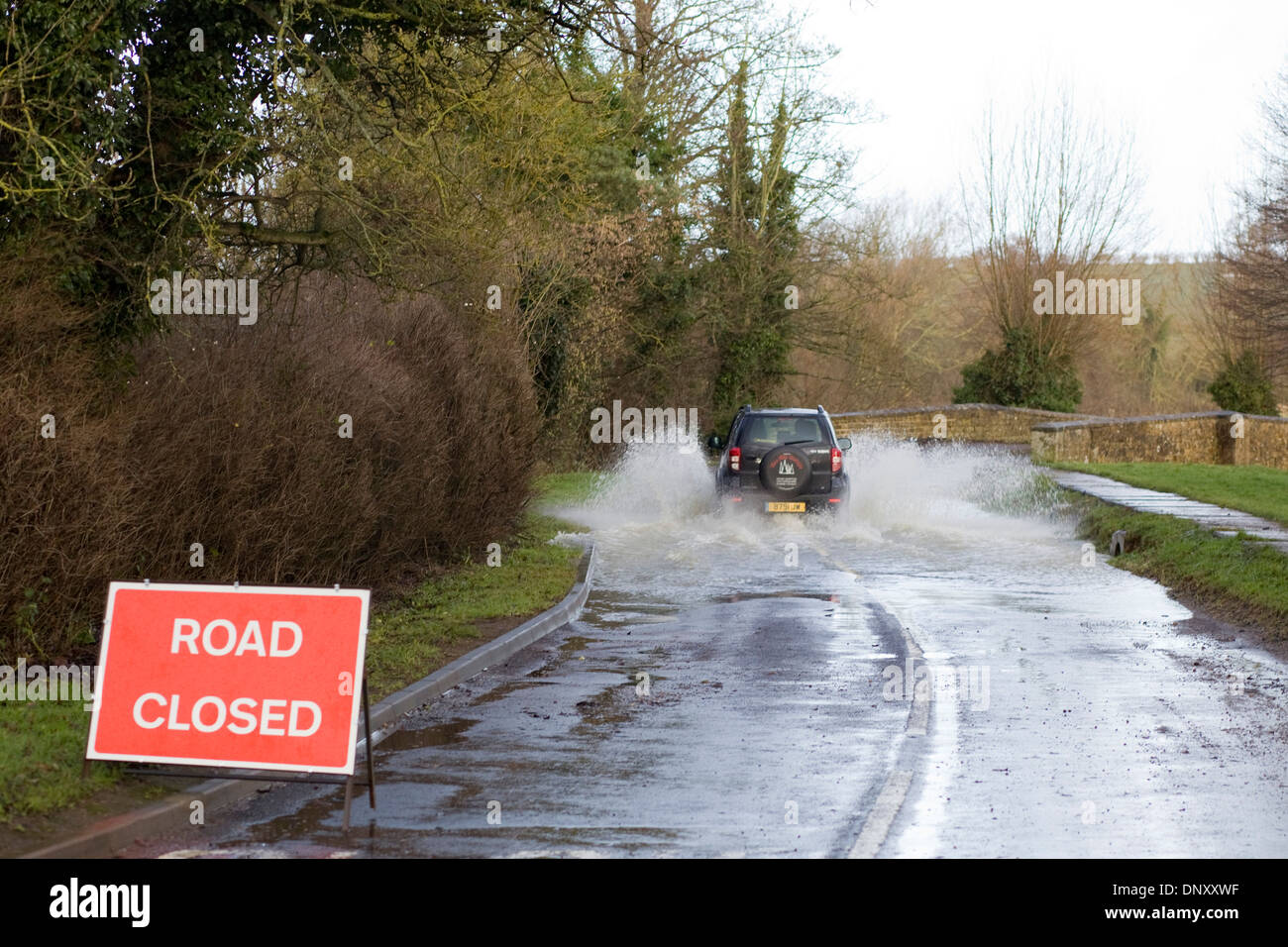 La conduite dans une route fermée en raison d'inondations faisant fi des conseils de signer Banque D'Images La conduite dans une route fermée en raison d'inondations faisant fi des conseils de signer Banque D'Images
