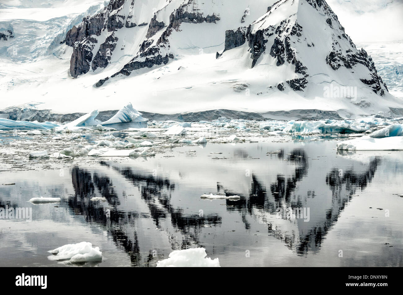 L'ANTARCTIQUE - une forte rocky mountain se reflète sur les eaux calmes comme vu de Cuverville Island sur le côté ouest de la péninsule antarctique. Banque D'Images