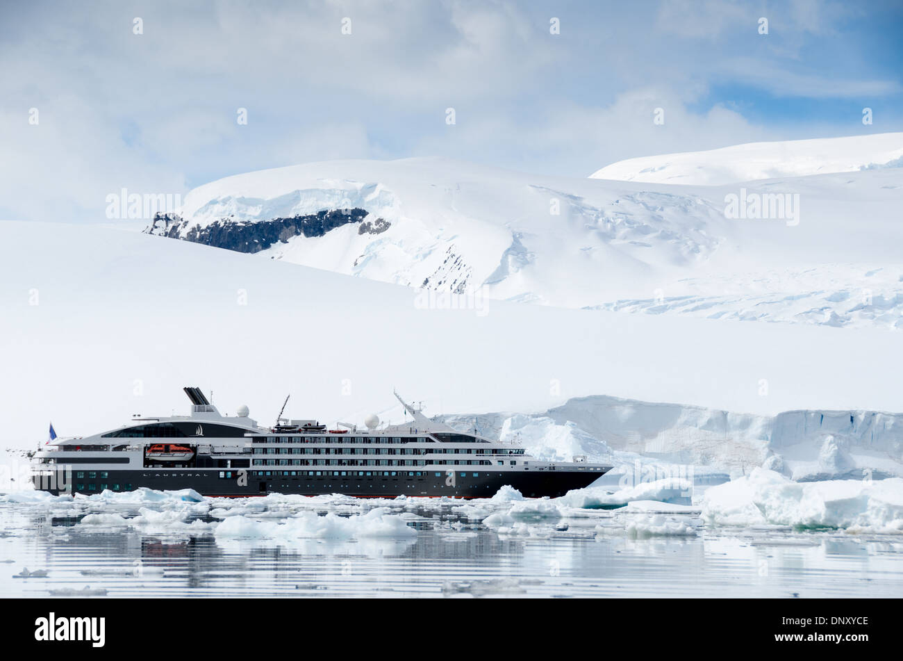 L'Austral Expedition Cruise Ship Antarctic Peninsula // ANTARCTIC PENINSULA, Antarctique — le navire d'expédition de luxe L'Austral, exploité par la ligne de croisière française PONANT, navigue prudemment à travers de la glace de sauge et de petits icebergs le long des imposantes falaises de glace de la péninsule Antarctique. Ce navire de 466 pieds (142 mètres), construit spécialement pour l'exploration polaire, transporte environ 200 passagers dans des logements de luxe tout en conservant des capacités de glace essentielles pour les eaux antarctiques. L'Austral représente le secteur croissant des croisières d'expédition qui permet aux touristes de découvrir la nature sauvage reculée d'Ant Banque D'Images