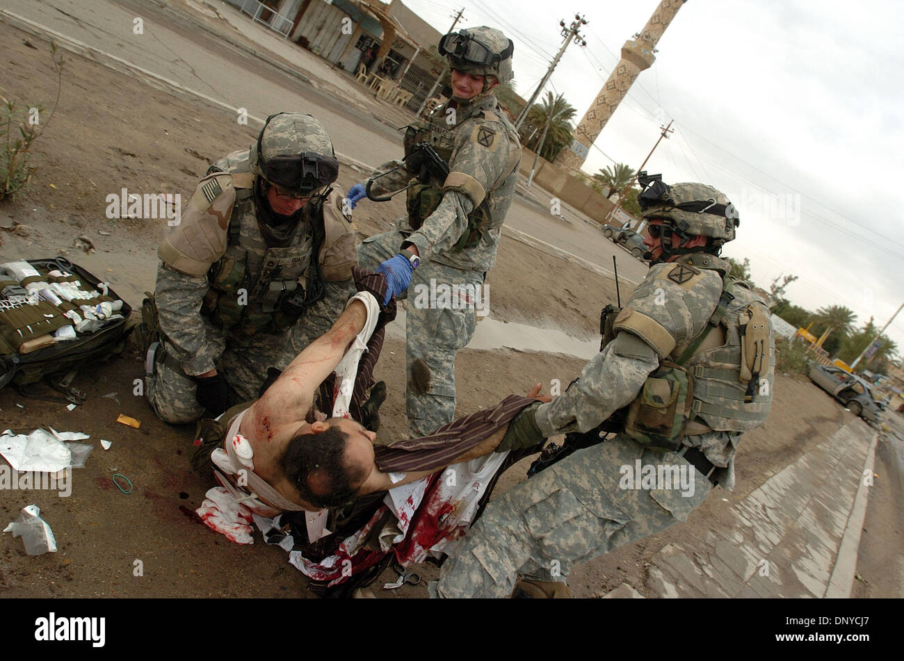Jan 26, 2006 ; Abu Ghraib, Bagdad, Irak, les soldats américains s'occuper d'un insurgé blessé à Bagdad le 26 janvier 2006. L'insurgé a été tué 20 fois au cours d'un échange de tirs entre soldats américains et une voiture de quatre insurgés. Ministère irakien de la Défense cartes d'identification et des seringues préremplies ont été trouvés dans la voiture avec quatre d'AK-47, une mitrailleuse PKM, un RPG de lancement, Banque D'Images