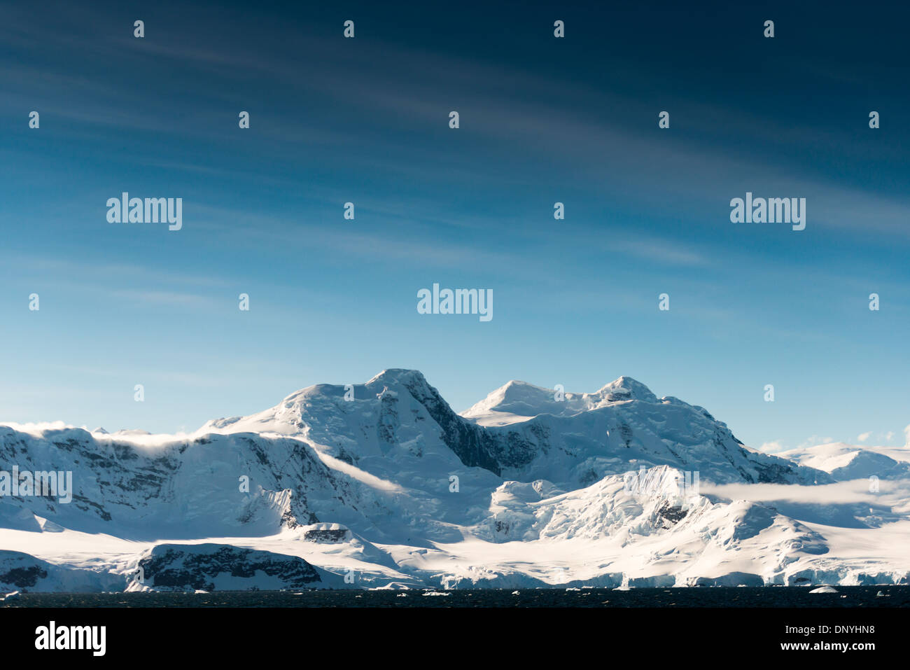 Détroit de Gerlache neige et montagnes de glace Antarctique // DÉTROIT DE GERLACHE, Antarctique — des montagnes spectaculaires recouvertes de neige et de glace s'élèvent du rivage du détroit de Gerlache, sur la côte ouest de la péninsule Antarctique. Cette région est connue pour ses paysages époustouflants et est un itinéraire populaire pour les croisières en Antarctique, offrant aux visiteurs la chance d'admirer les formations glaciaires uniques du continent et la diversité de la faune. Le détroit porte le nom d'Adrien de Gerlache, un explorateur belge qui a mené une expédition dans la région à la fin du XIXe siècle. Banque D'Images