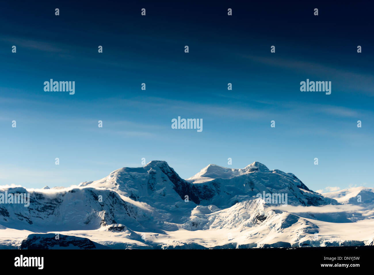 Détroit de Gerlache neige et montagnes de glace Antarctique // DÉTROIT DE GERLACHE, Antarctique — des montagnes spectaculaires recouvertes de neige et de glace s'élèvent du rivage du détroit de Gerlache, sur la côte ouest de la péninsule Antarctique. Cette région est connue pour ses paysages époustouflants et est un itinéraire populaire pour les croisières en Antarctique, offrant aux visiteurs la chance d'admirer les formations glaciaires uniques du continent et la diversité de la faune. Le détroit porte le nom d'Adrien de Gerlache, un explorateur belge qui a mené une expédition dans la région à la fin du XIXe siècle. Banque D'Images