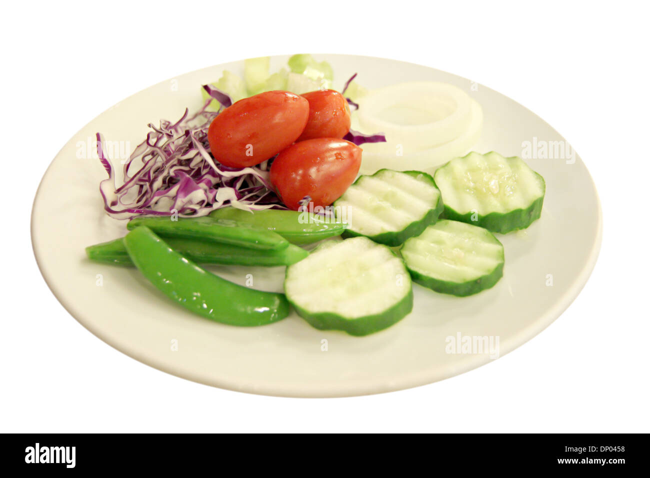 Tomate et concombre placés dans le plat sur fond blanc. Banque D'Images