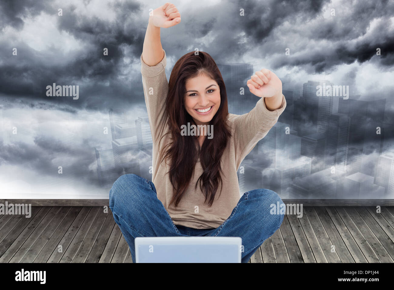 Image composite de femme regarde droit devant alors qu'elle célèbre en face de son ordinateur portable Banque D'Images