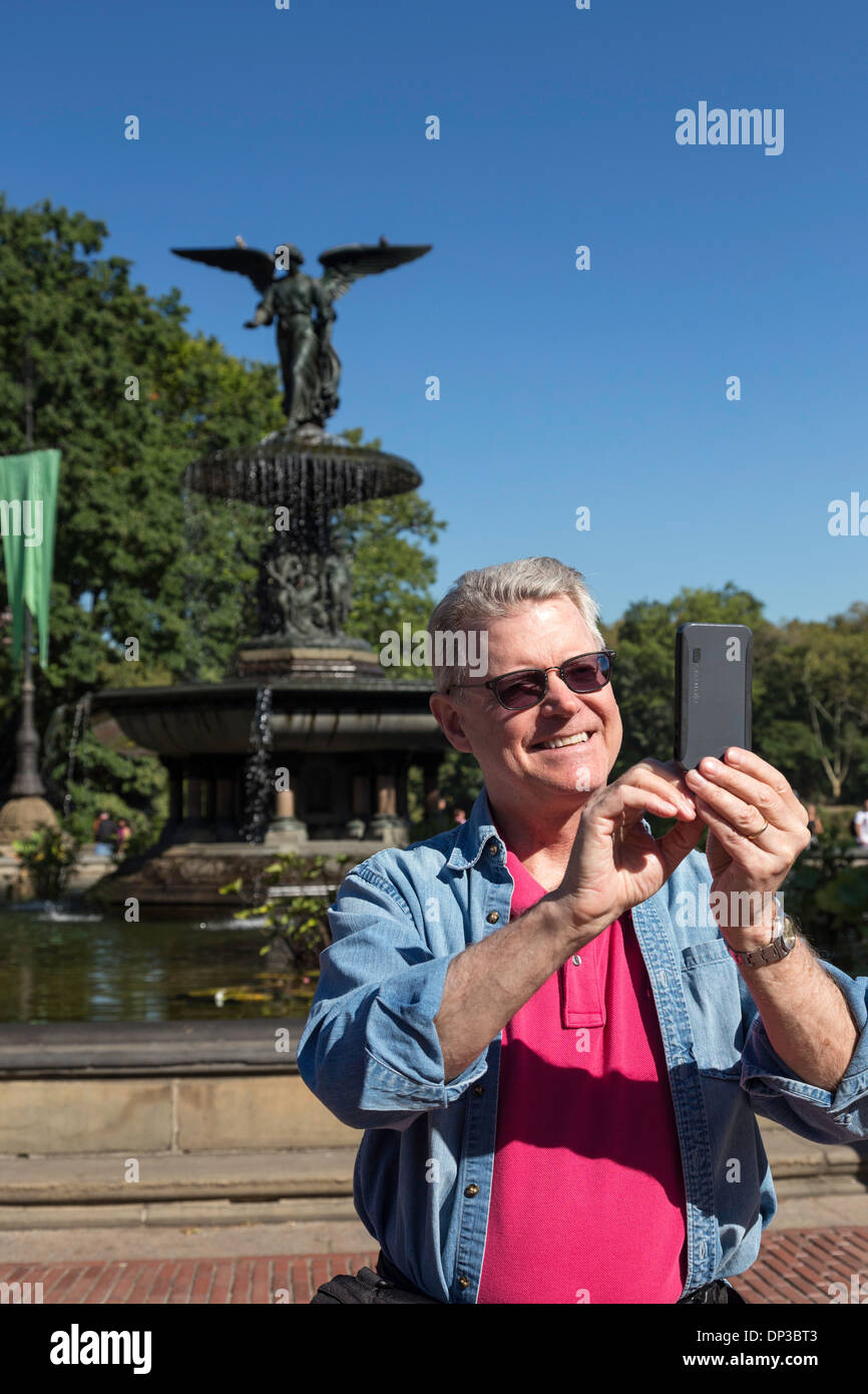Man Selfies un avec un périphérique cellulaire chez Bethesda Plaza à New York Banque D'Images