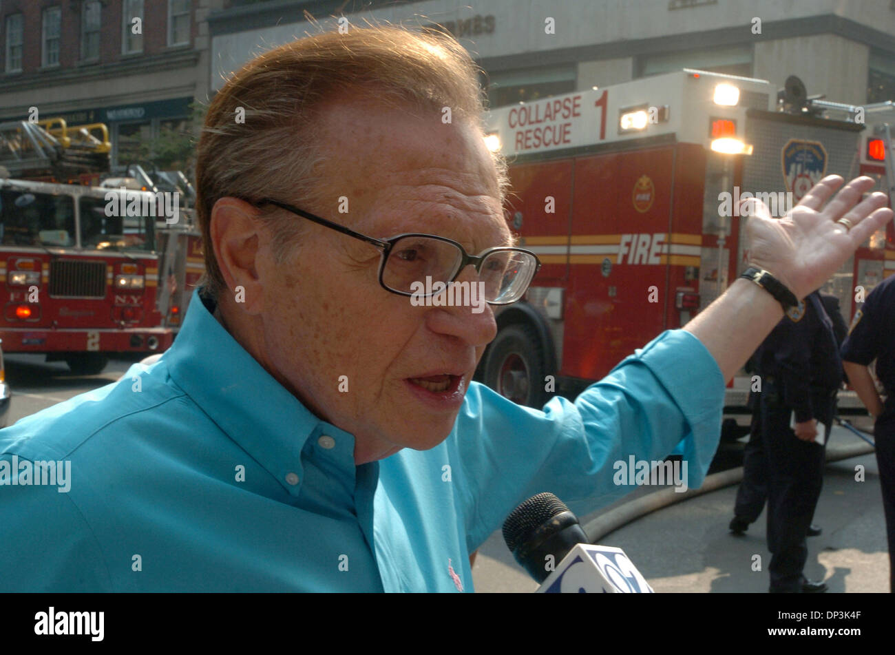 10 juil 2006, Manhattan, NY, USA ; Larry King de CNN décrit la scène après avoir entendu l'explosion, tout en restant dans un hôtel voisin. Les pompiers travaillent d'éteindre un feu qu'ils répondent à un immeuble de quatre étages s'effondrer à la suite d'une explosion. L'édifice qui abrite un bureau de médecin et situé sur Madison Avenue sur l'Upper East Side s'est effondré et les pompiers blessés civilia Banque D'Images