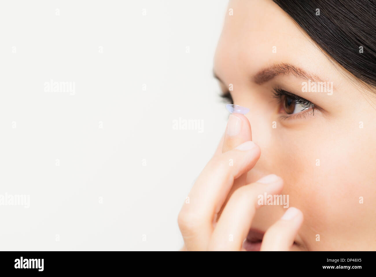 Femme au sujet de placer une lentille de contact dans les yeux Banque D'Images