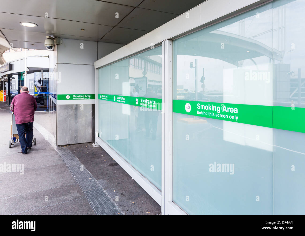 La marche avec des sacs de passagers de l'aéroport passé fumeurs Banque D'Images La marche avec des sacs de passagers de l'aéroport passé fumeurs Banque D'Images