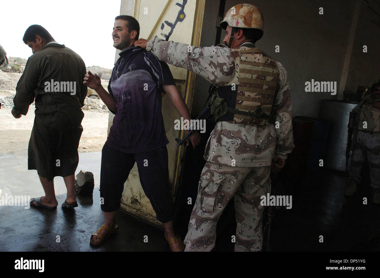 Aug 29, 2006 ;, Saluhiddin Bayji, IRAQ, un soldat de l'armée iraquienne pousse un homme soupçonné de vendre et de stockage de carburant blackmarket hors de sa boutique dans la mécanique, l'Irak. Bayji Les soldats ont trouvé près de 4 000 gallons de carburant dans son magasin. Les soldats de l'armée iraquienne, 4e Bataillon, 2e Brigade, 4e Division, et l'American's Co. A, 1er du 187e d'infanterie, ont été la répression de blackmar Banque D'Images