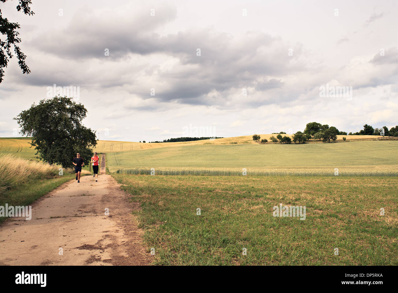 Les gens marcher sur la route en face du paysage rural Banque D'Images