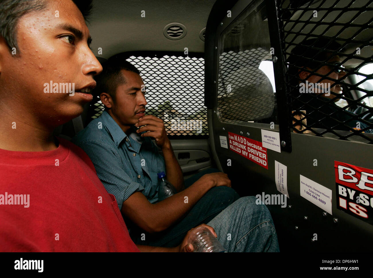 Oct 05, 2006 ; nation Tohono O'odham, USA ; Frères RICARDO, gauche, et Rodrigo SALAZAR était assis à l'arrière d'une voiture de police conduit par le Sgt. BEGAY Elton de la nation Tohono O'odham force de police. Les migrants ont été heureux d'être à l'abri du soleil et dans un véhicule climatisé après avoir passé des jours à traverser le désert et d'être abandonnés par leur 'coyote'. BEGAY les menait à un endroit où Banque D'Images