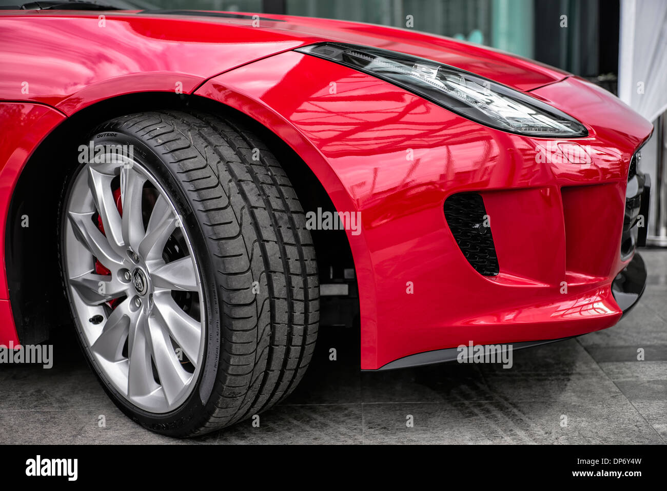 Jaguar F type. Détail pneu et aile Pirelli P Zero d'une voiture de sport convertible Jaguar F type britannique en rouge. Banque D'Images