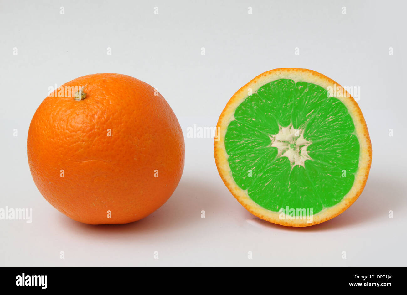 Couper une orange pour montrer l'intérieur de couleur verte contre nature Banque D'Images