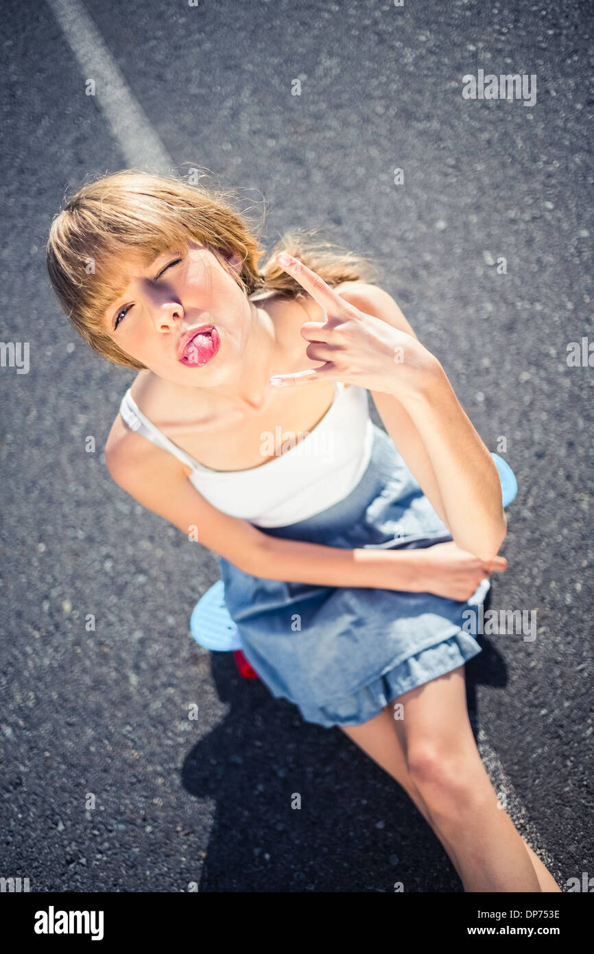 Trendy young woman making rock and roll hand gesture Banque D'Images