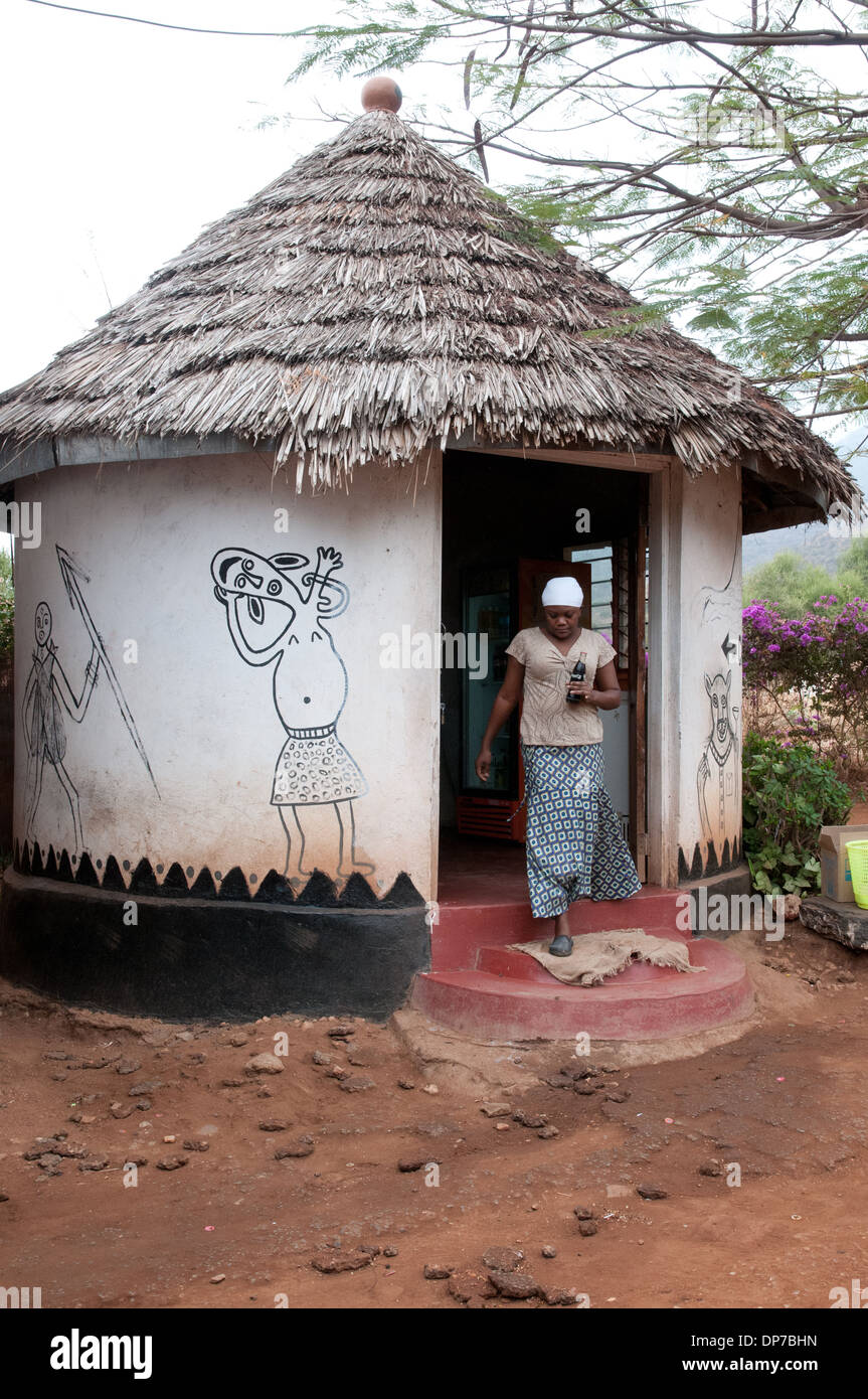 La boue et wattle rondavel avec toit de chaume et de l'Afrique de l'imagination d'art mural à duka halte touristique Namanga Kenya Afrique Banque D'Images