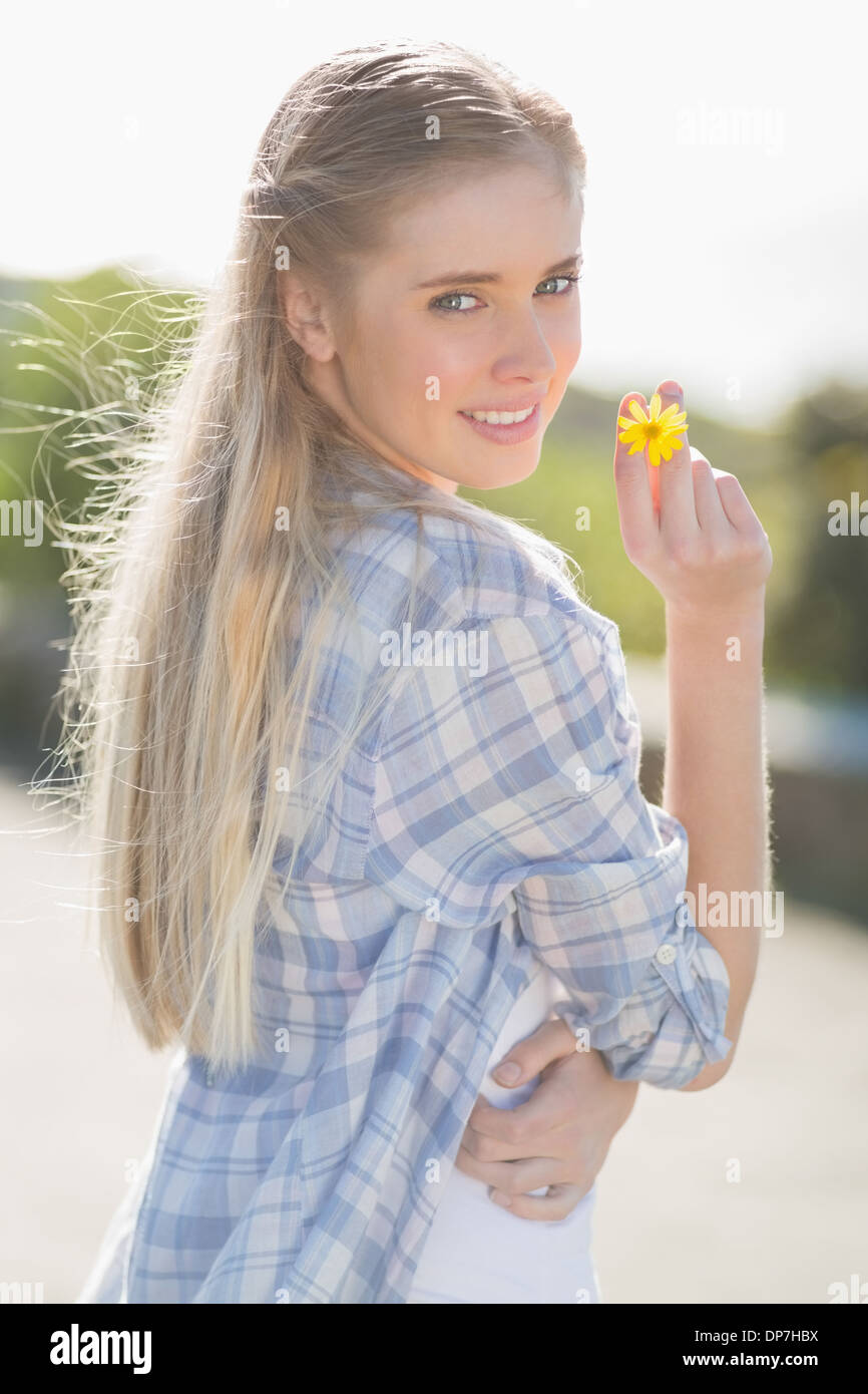 Femme tenant des fleurs jaunes dans la main Banque D'Images