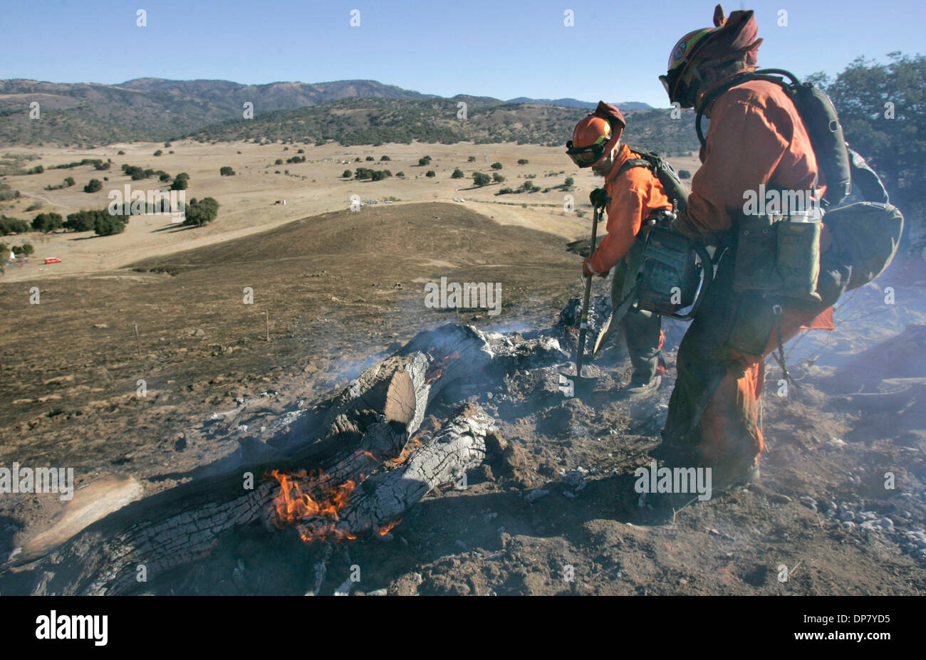 Nov 30, 2006 ; Santa Ysabel, CA, USA ; Pompiers LISA MULLINS, à gauche avec une pelle, et KELLY SOTO, plus à droite avec une tronçonneuse, travailler sur un "Smokey", encore un hot spot, près de l'origine du feu dans cette vue à la sud-est. Y'a pas de point d'origine est indiqué en descente dans la distance, la section du milieu de la photo. Crédit obligatoire : Photo par Charlie Neuman Banque D'Images