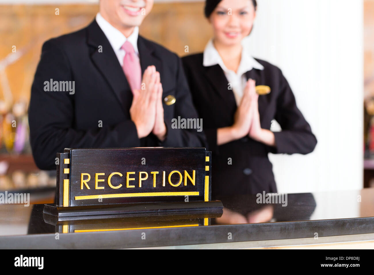 L'équipe de réception asiatique chinois à l'hôtel de luxe/24 accueille les clients avec des geste, un signe de bon service Banque D'Images