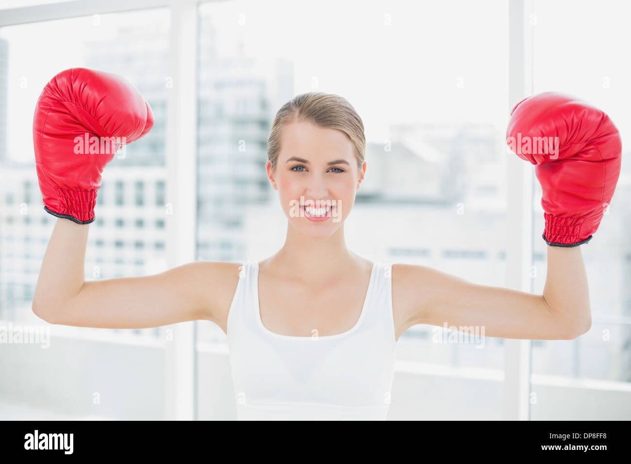 Cheerful woman concurrentiel with red boxing gloves cheering up Banque D'Images