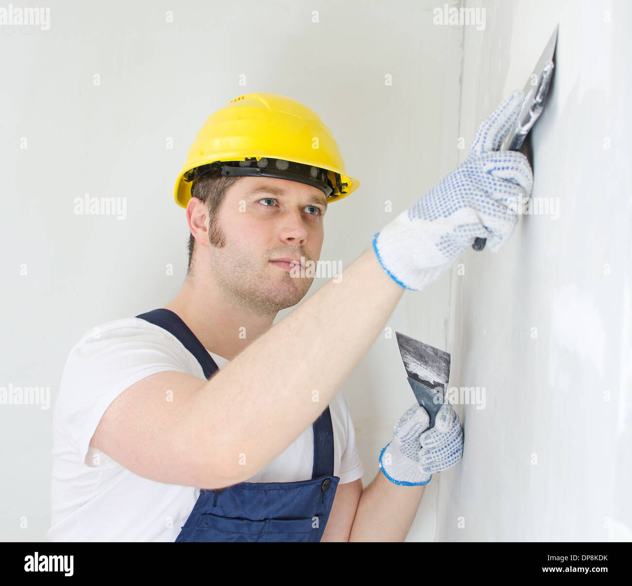Constructeur mâle mur avec de la pâte à reboucher les réparations Banque D'Images