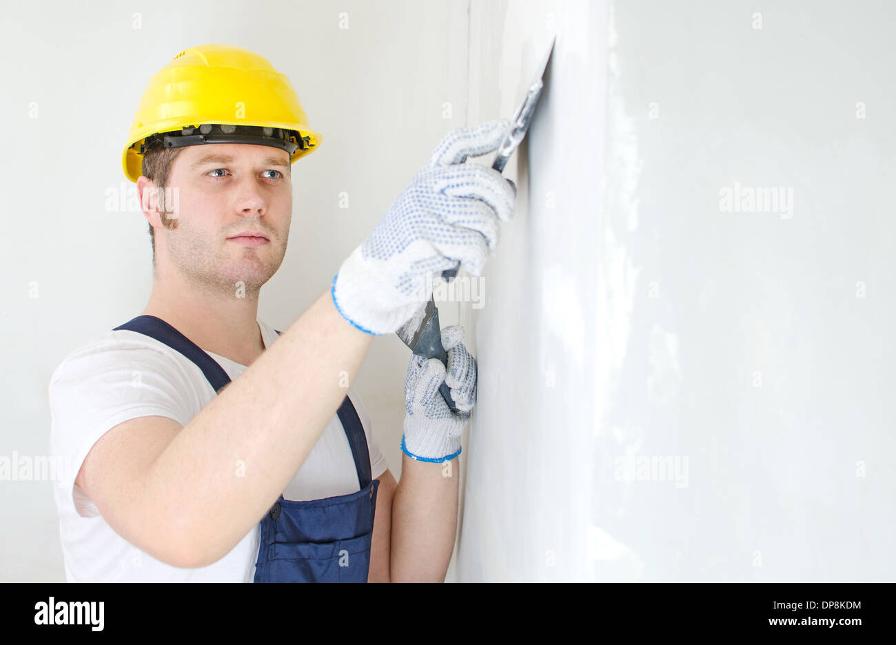 Constructeur mâle mur avec de la pâte à reboucher les réparations Banque D'Images