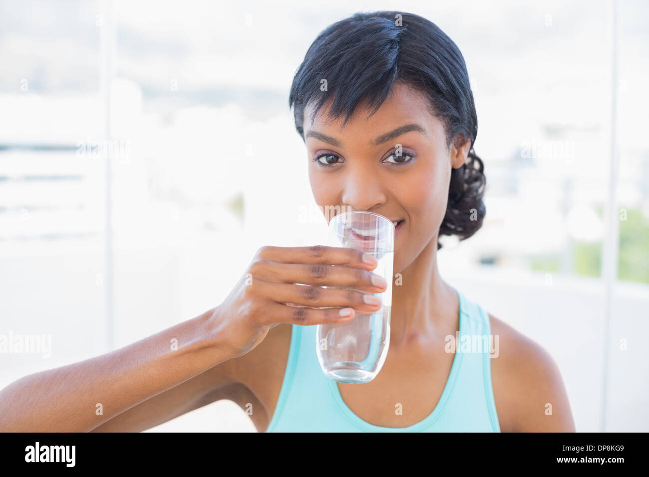 Charmante femme aux cheveux noirs de boire un verre d'eau Banque D'Images