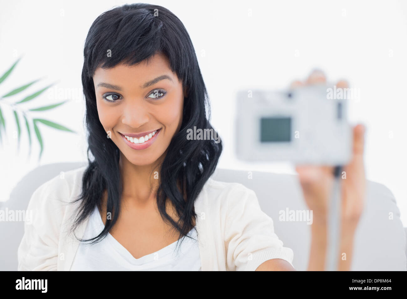 Natural black haired woman en blanc de prendre une photo d'elle-même Banque D'Images