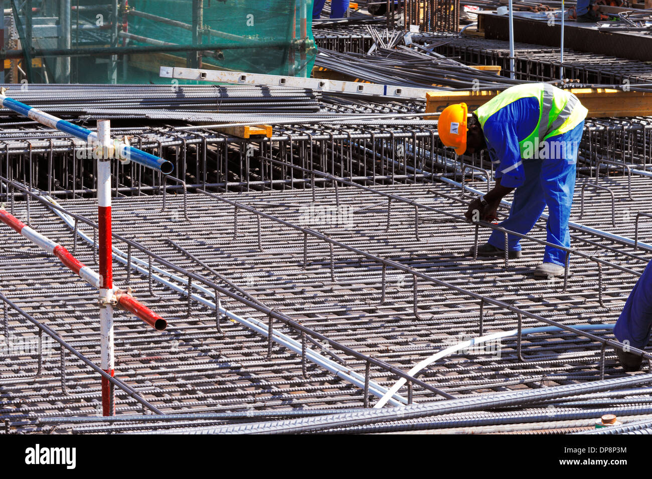 Un fixateur en acier renforcé de liage avec soin les barres d'acier en position en vue de la construction d'une dalle de béton Banque D'Images