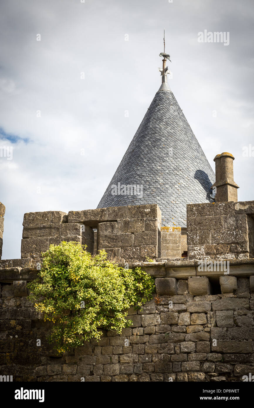 Carcassonne. La France, l'Europe. 'Vieux chapeau de sorcière' toit, se tenant au-dessus de l'ancien mur de la ville en pierre. Banque D'Images