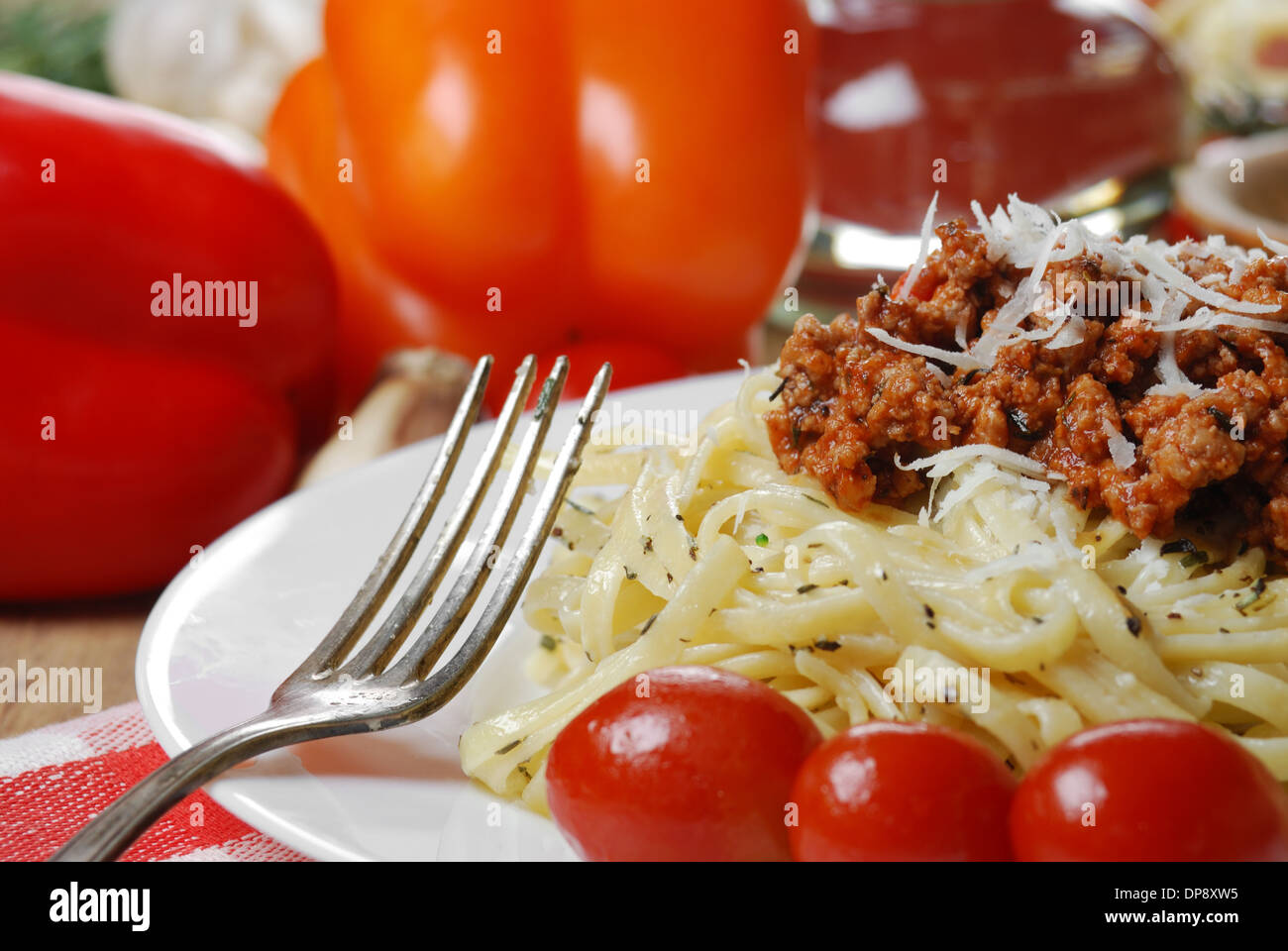 Les pâtes à la bolognaise dans la plaque blanche sur la table en bois avec des légumes Banque D'Images