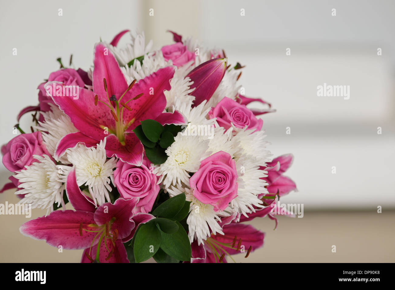 Bouquet de fleurs roses et blanches dans une chambre avec un canapé ou canapé dans l'arrière-plan Banque D'Images