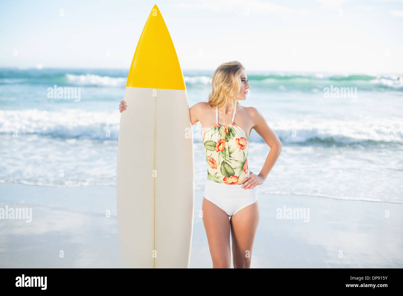 Thoughtful Blonde modèle en maillot tenant une planche de surf Banque D'Images