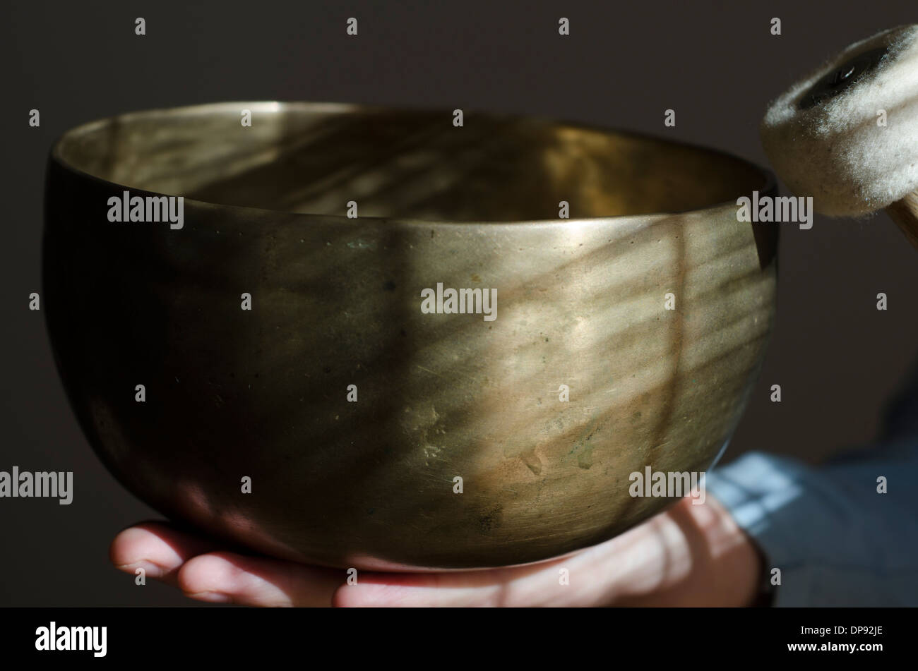 Grand bol chantant tibétain et baton n'est tenue. Banque D'Images