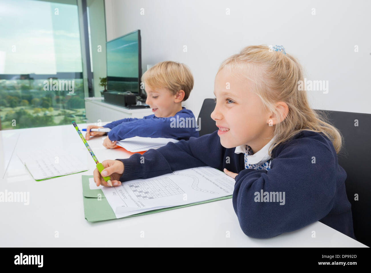 Frère et soeur à faire des devoirs à table dans la maison Banque D'Images