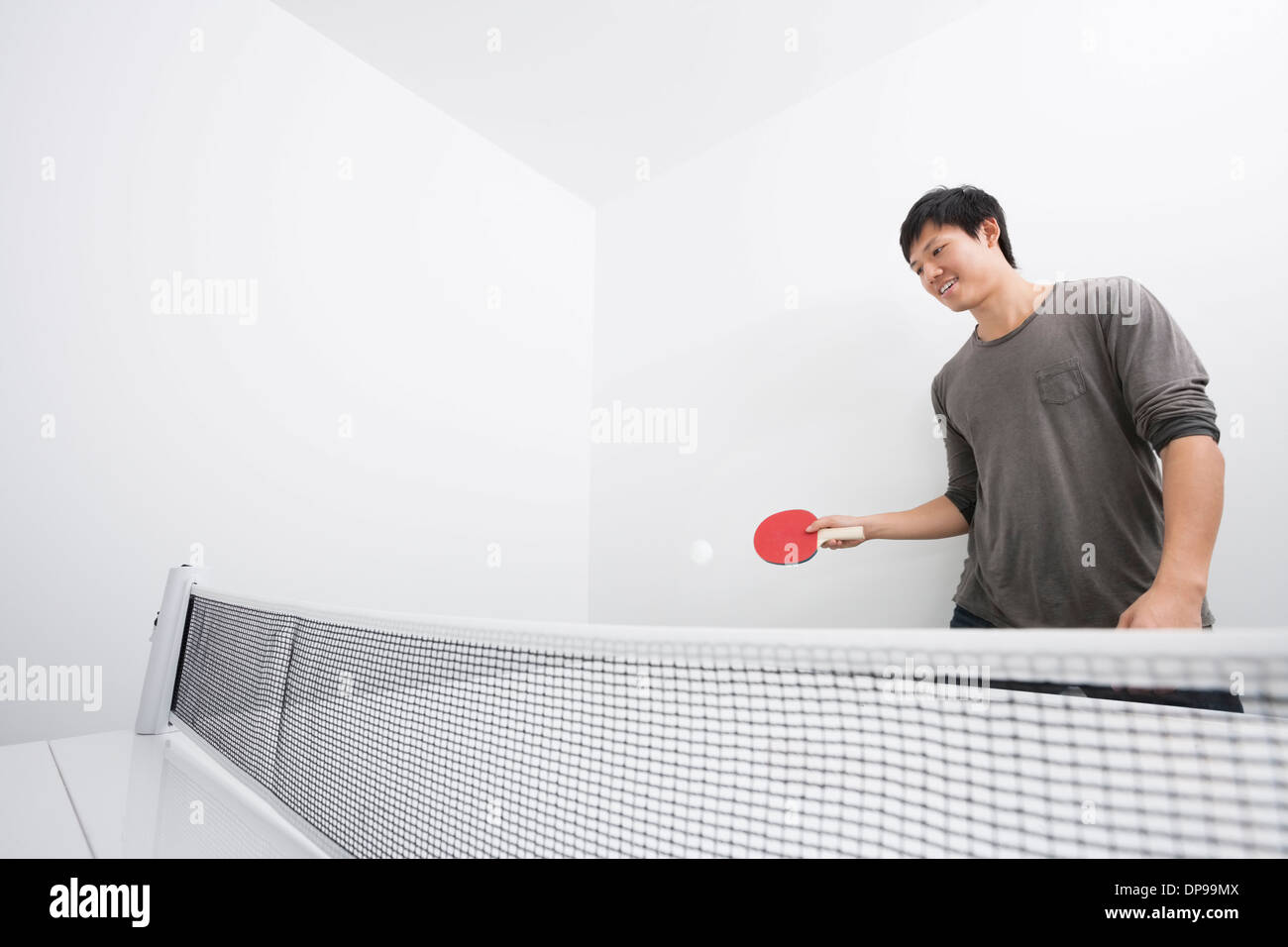 Asian Mid adult man jouer au ping-pong Banque D'Images