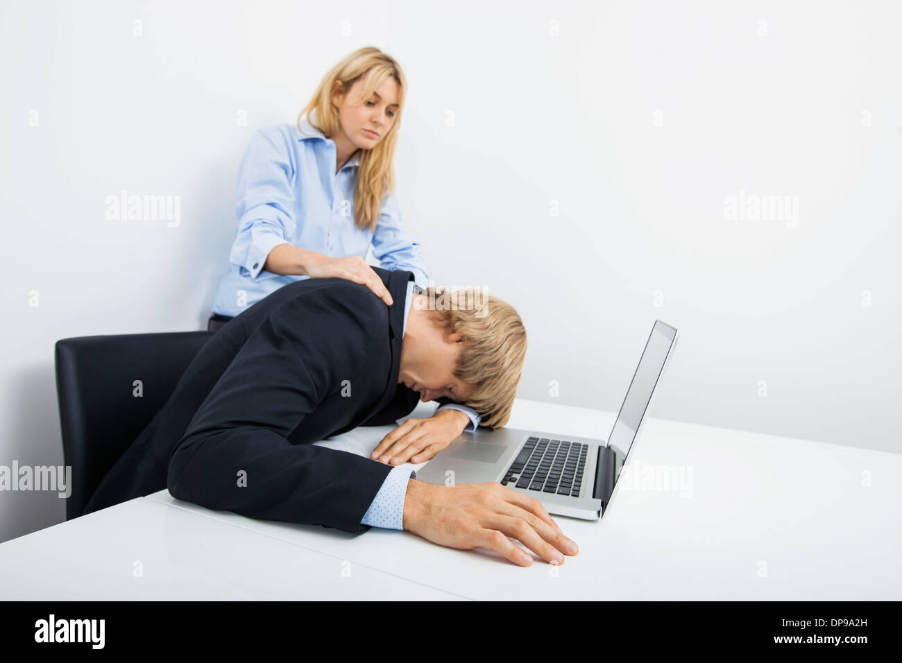 Avec un collègue d'affaires surmenés at desk in office Banque D'Images