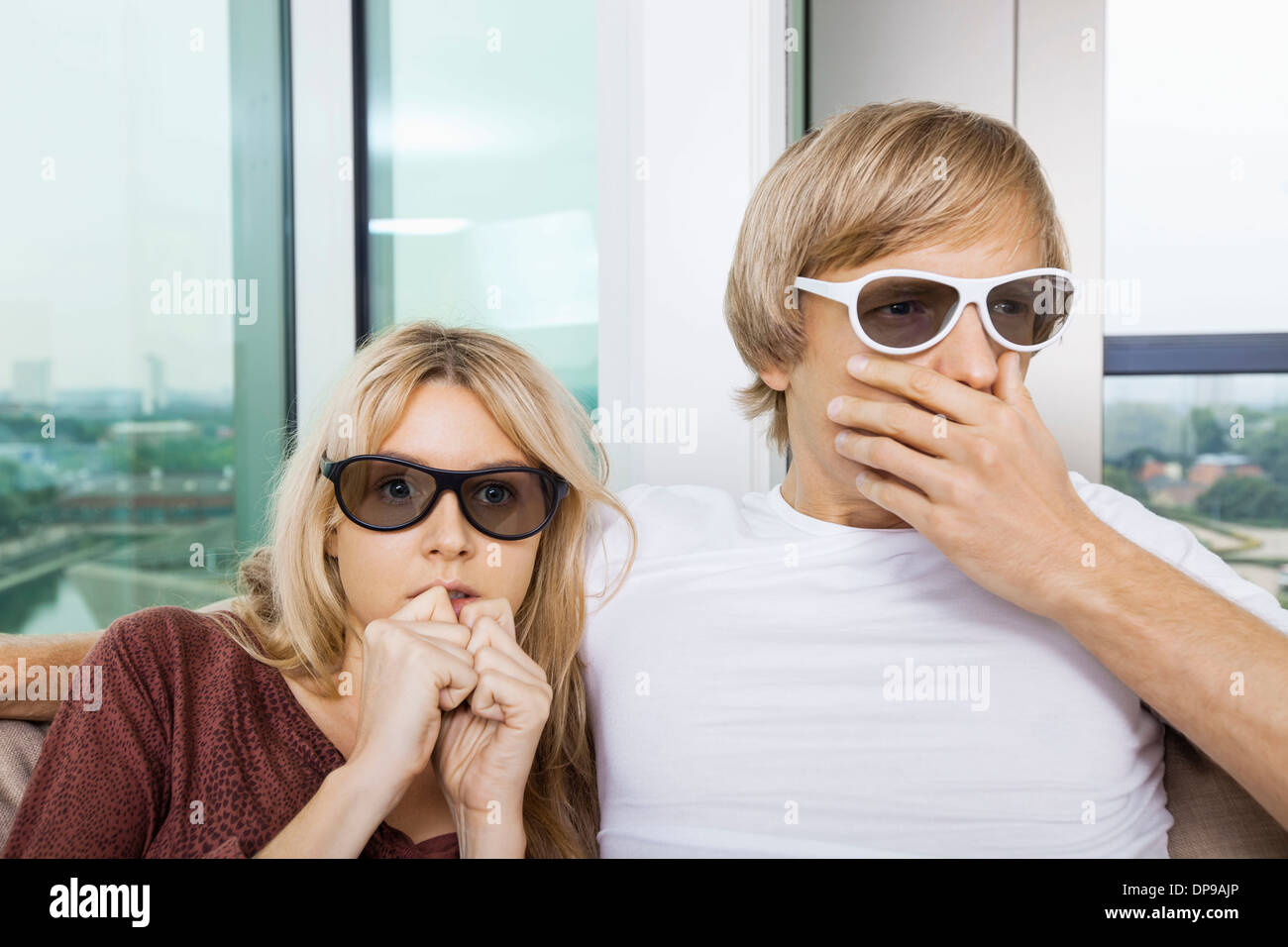 Couple portant des lunettes 3D et regarder la télévision avec la concentration à la maison Banque D'Images