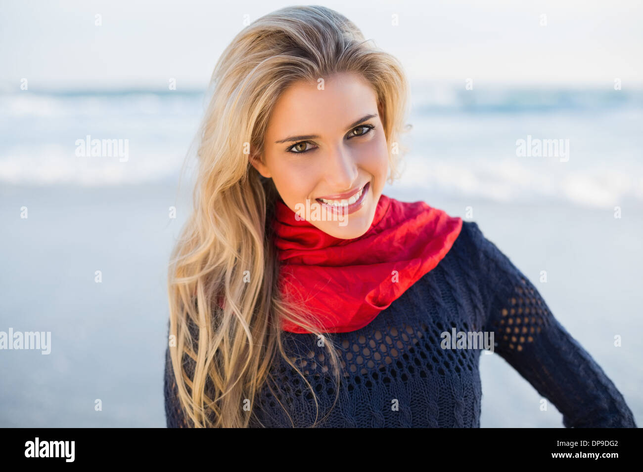 Cheerful gorgeous blonde avec écharpe rouge posing Banque D'Images